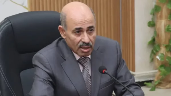 Portrait du professeur Farid Kourtel, nouveau conseiller économique de Tebboune, devant le palais présidentiel d'Alger.