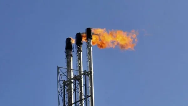 Ligne à haute tension traversant le désert saharien algérien sous un ciel dégagé, symbole du paradoxe entre potentiel solaire inexploité et dépendance au gaz naturel