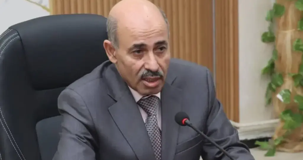Portrait du professeur Farid Kourtel, nouveau conseiller économique de Tebboune, devant le palais présidentiel d'Alger.