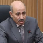 Portrait du professeur Farid Kourtel, nouveau conseiller économique de Tebboune, devant le palais présidentiel d'Alger.